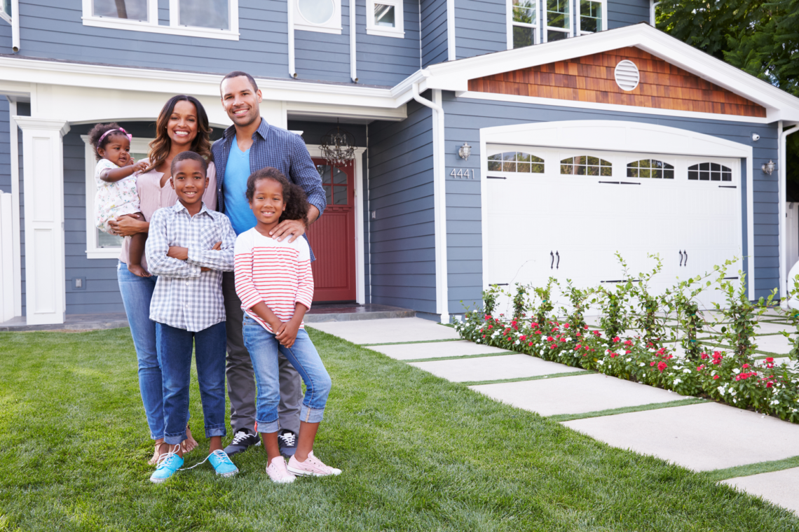 A family in front of a new home